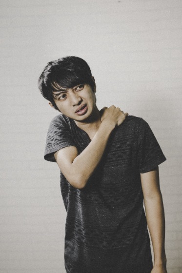 肩に手を当てる男性