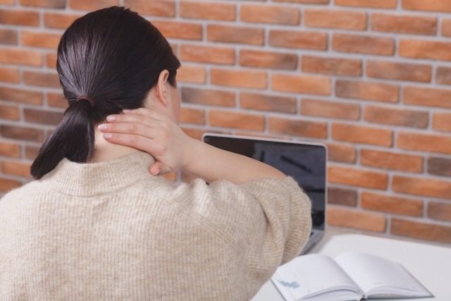 首をおさえる女性