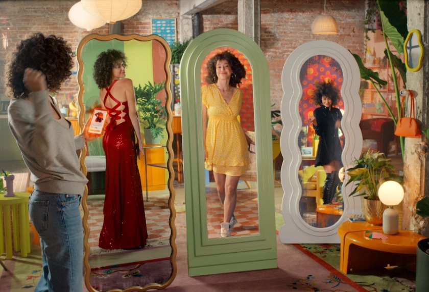 鏡でいろんな服を見ている女性の写真