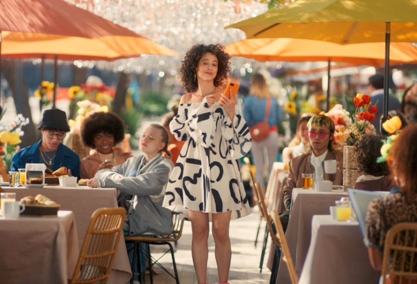 オレンジのスマホを持った海外の女性の写真