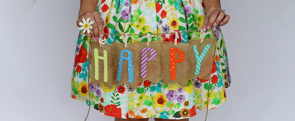 女の子が持つカラフルなHAPPYのロゴ