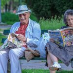 ベンチで雑誌を読む老夫婦