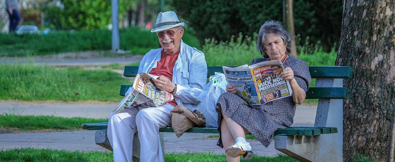 ベンチで雑誌を読む老夫婦