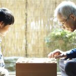 縁側で将棋を打つ祖父と孫