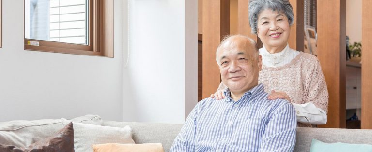 座っている男性と肩に手を添える女性