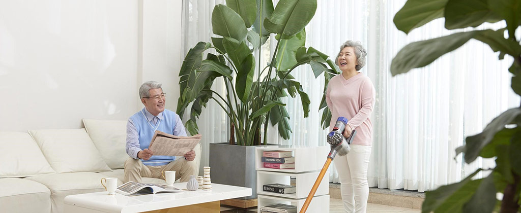 新聞を読む男性と掃除機をかける女性