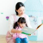絵本を読む保育士と子供