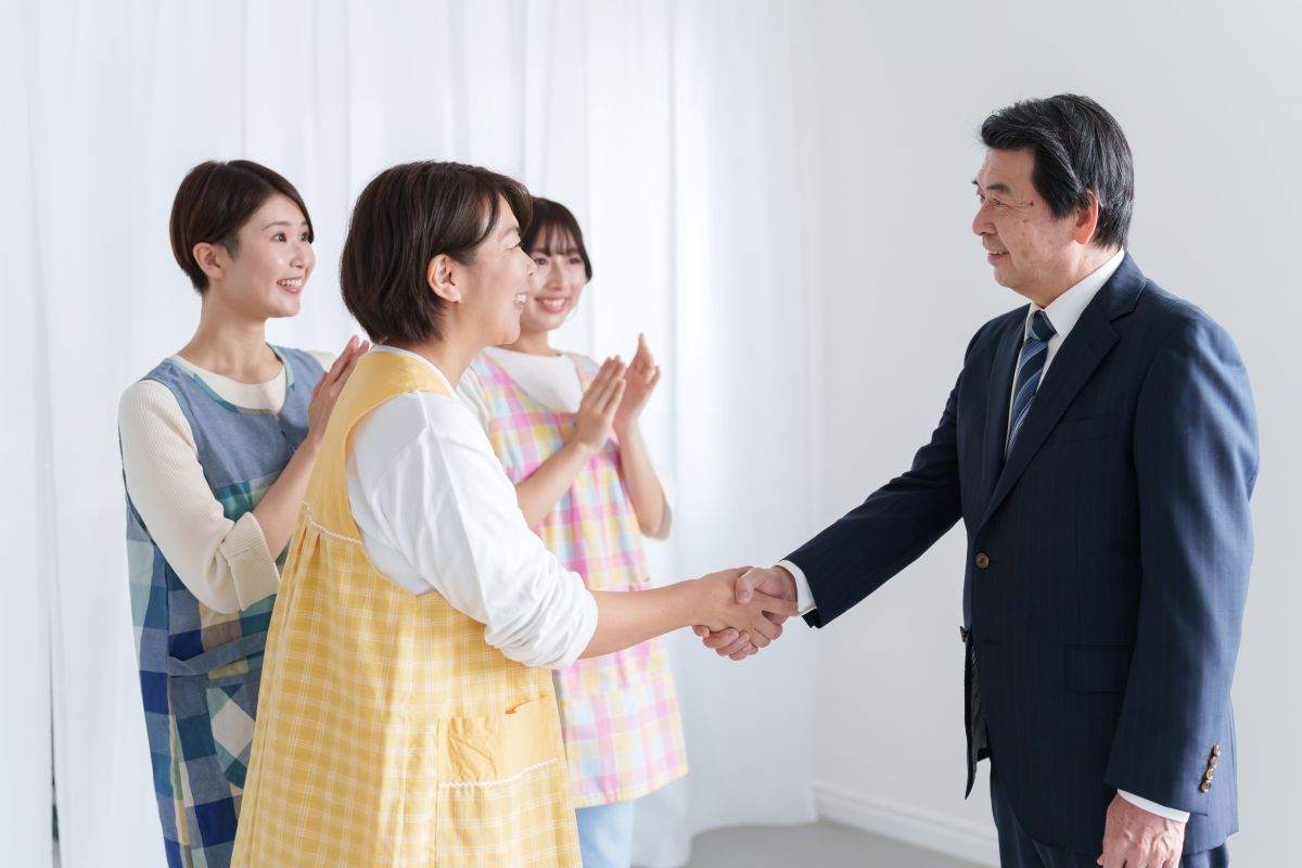 園長と握手する保育士