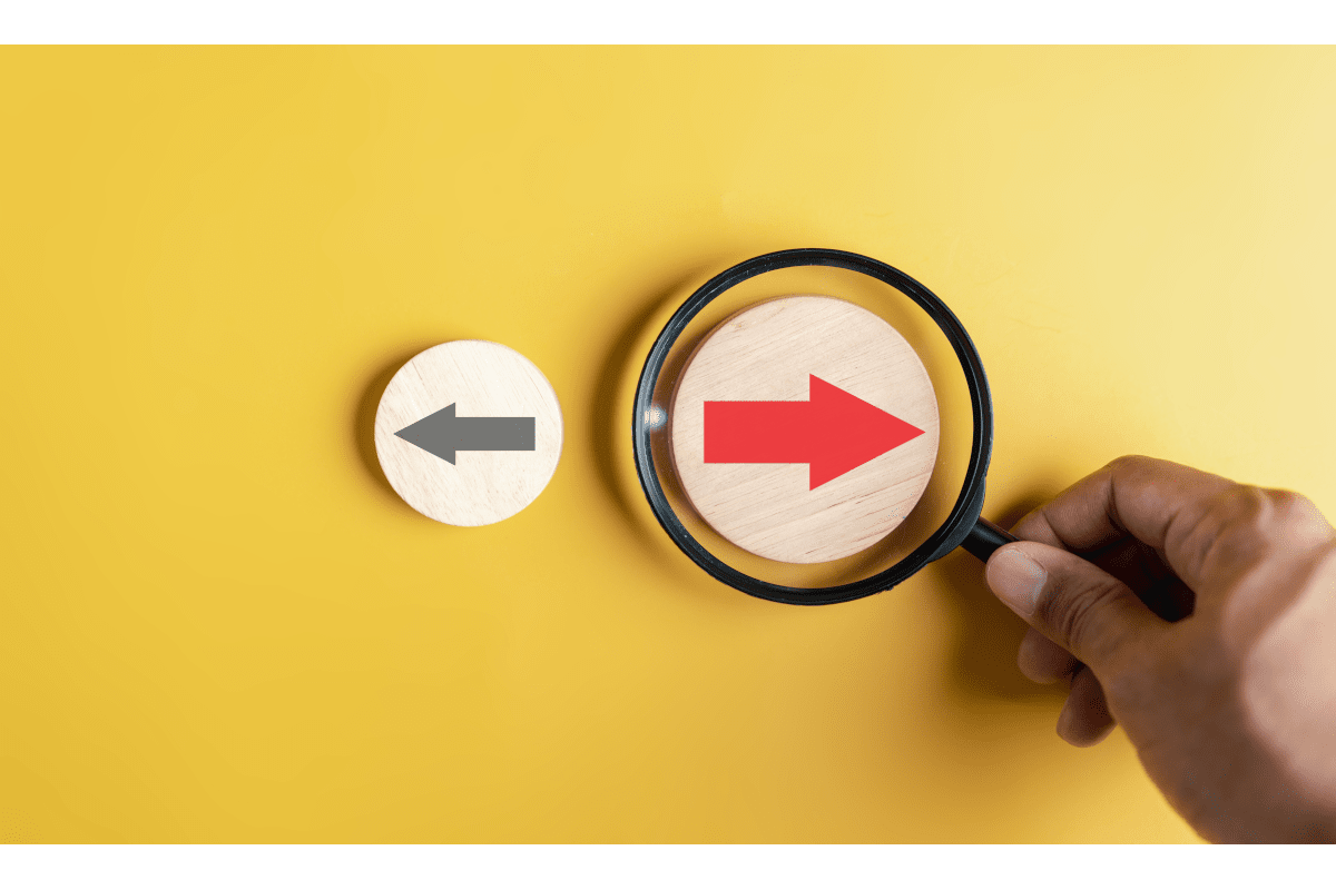 赤い矢印に虫眼鏡を当てる手