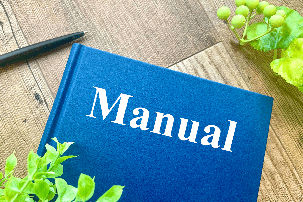 Manualと書かれた本と植物とペン