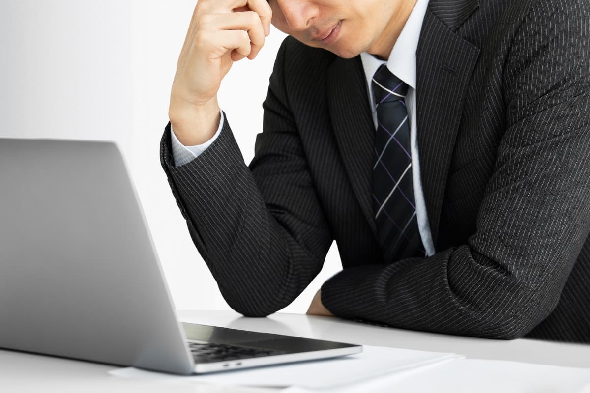 パソコン画面を見て悩む男性会社員