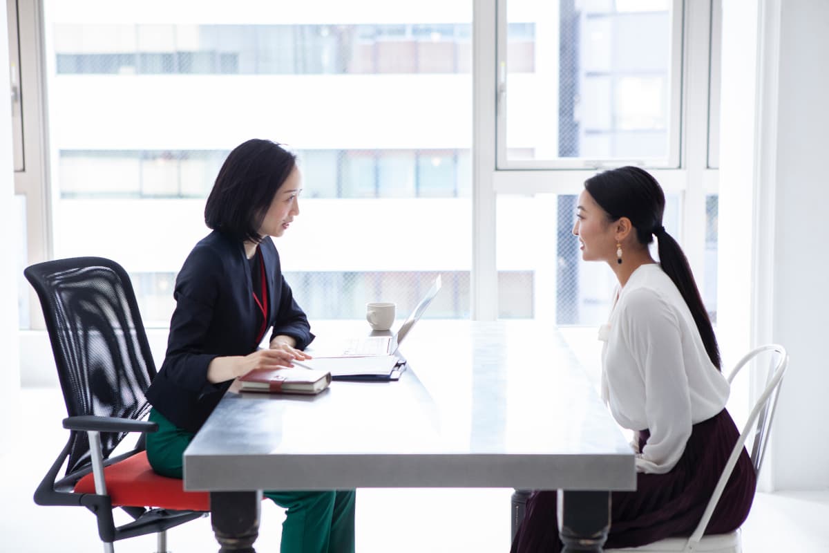社内で打ち合わせをする二人の女性