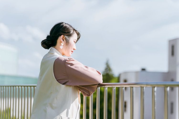 屋上で悩んでいる女性