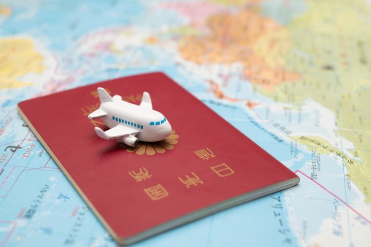 地図の上に乗ったパスポートと飛行機の模型