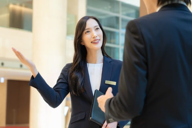 お客様を案内する女性のホテルコンシェルジュ