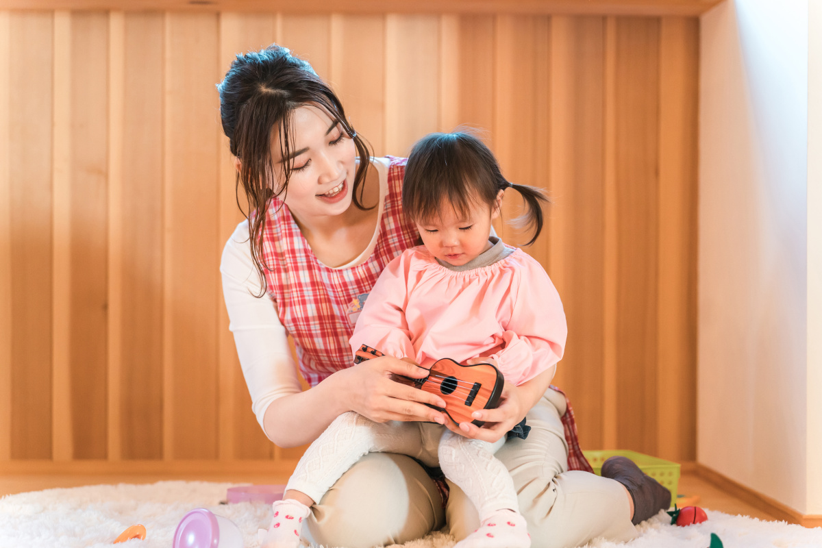 子どもと一緒に遊ぶ保育士