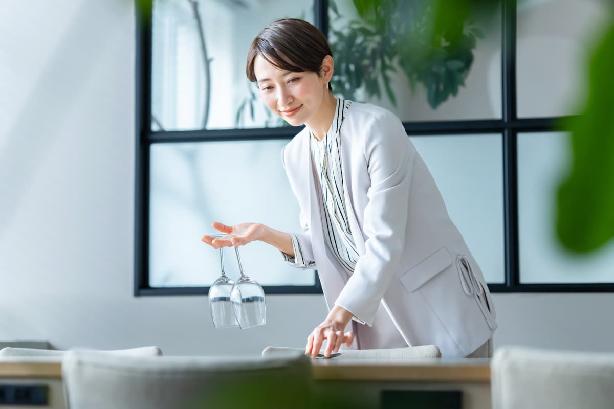 テーブルのセッティングをする女性スタッフ