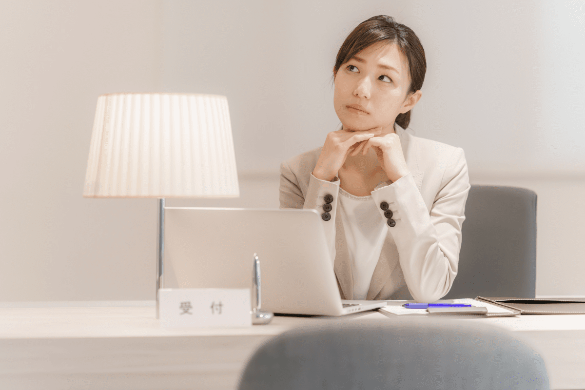 考えるホテルフロントの女性