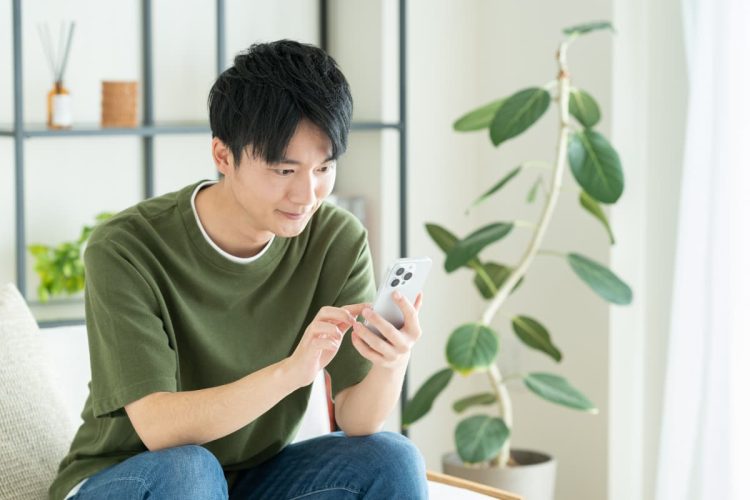 スマホで調べ物をする男性