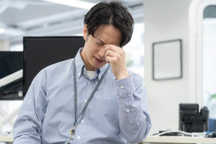仕事での疲れを感じている男性
