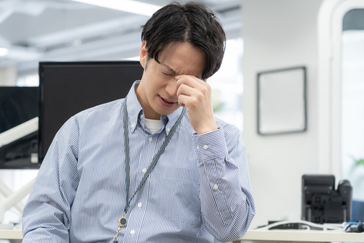 仕事での疲れを感じている男性
