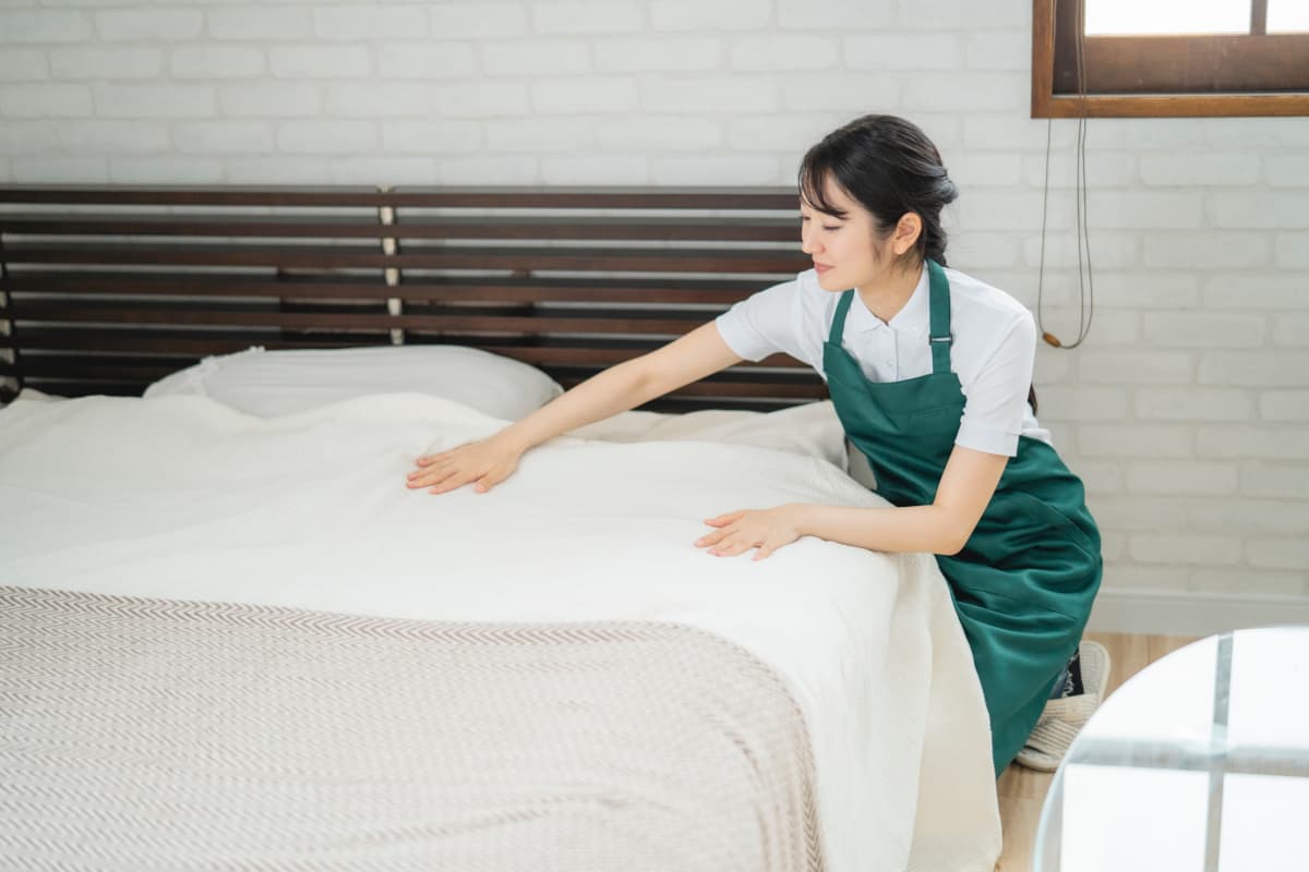 ホテルのベッドメイクをする女性スタッフ