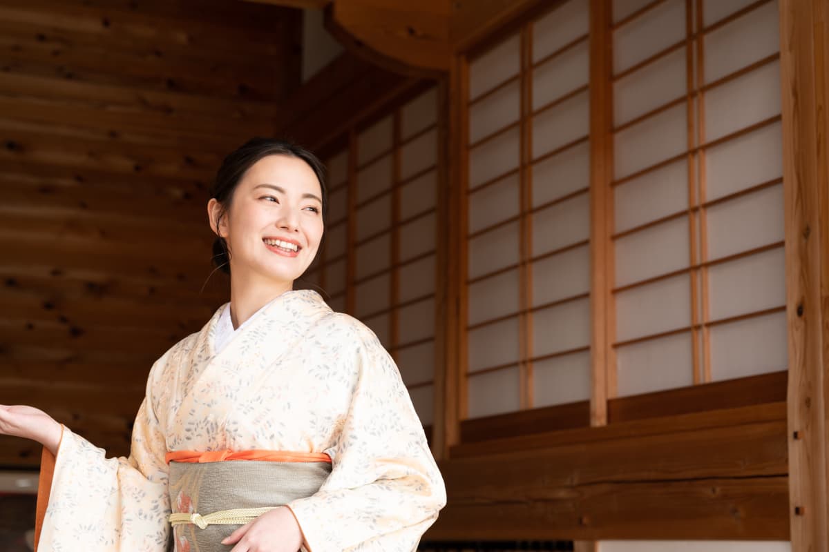 旅館の入り口でお出迎えする女将