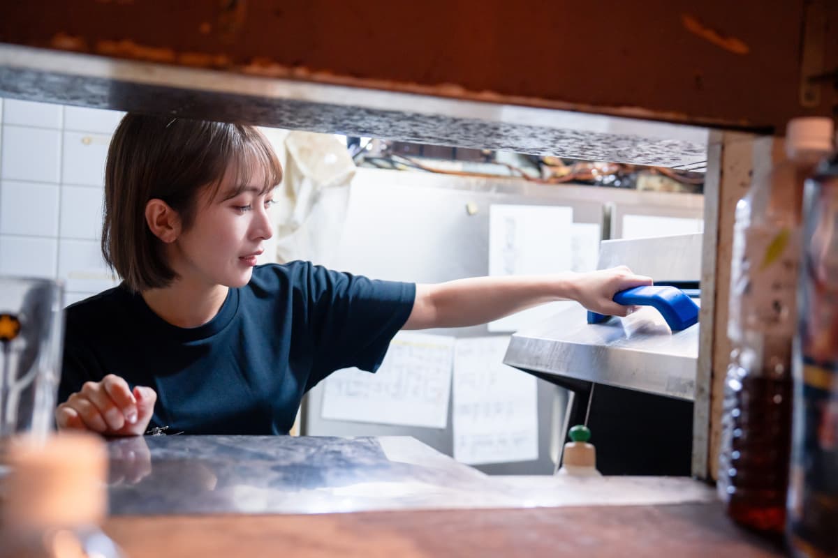 食洗器を使う飲食店の女性