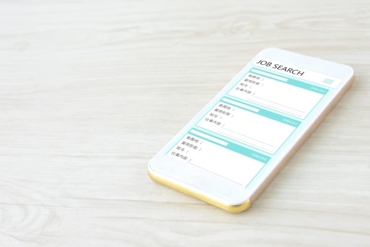テーブルの上に置いてある求人票画面のスマホ