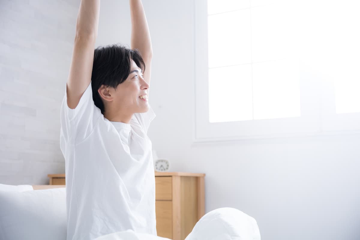 寝起きに爽やかな朝を迎えた男性