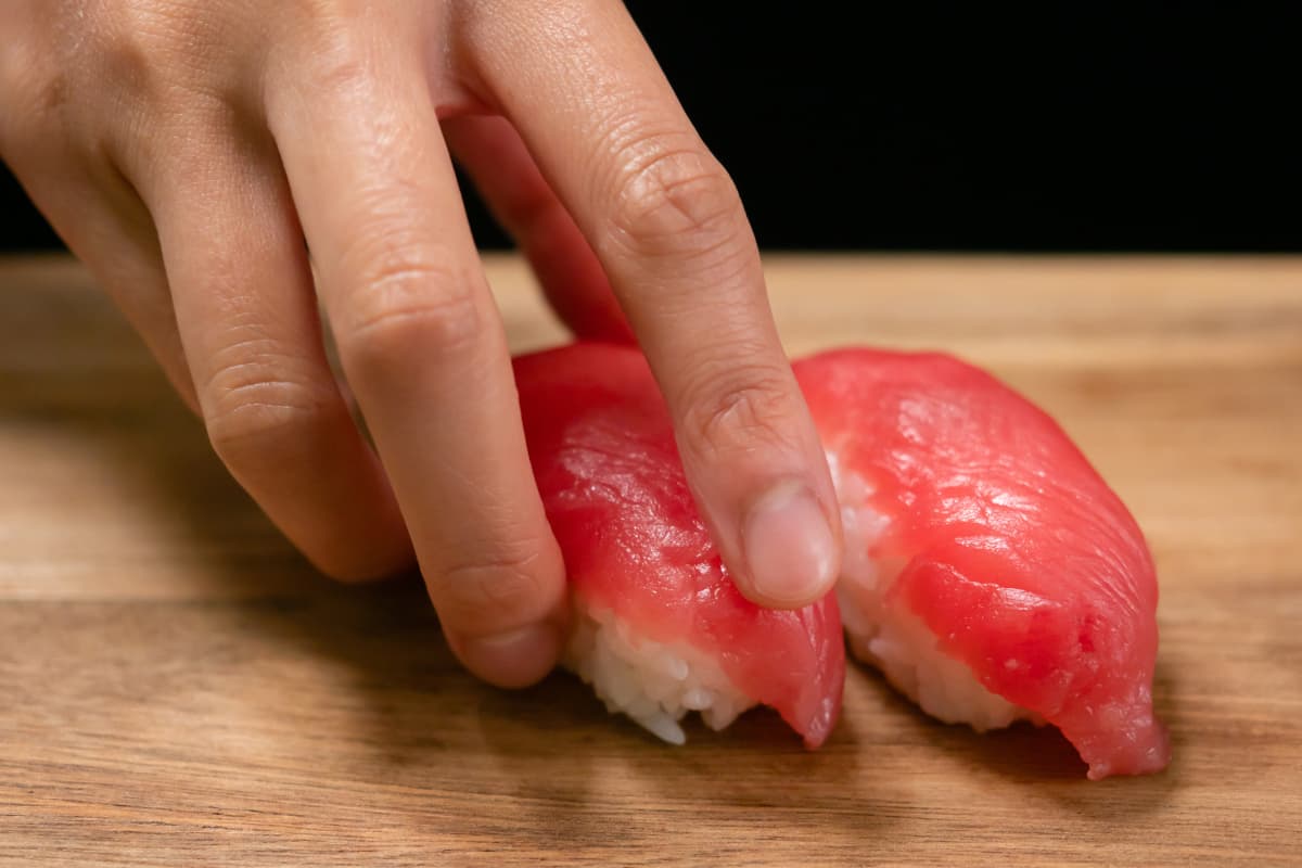 まぐろを握っている寿司職人の手