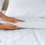 ベッドメイクをする人の手