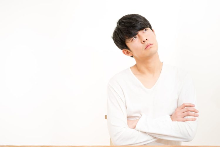 腕を組んで考える男性