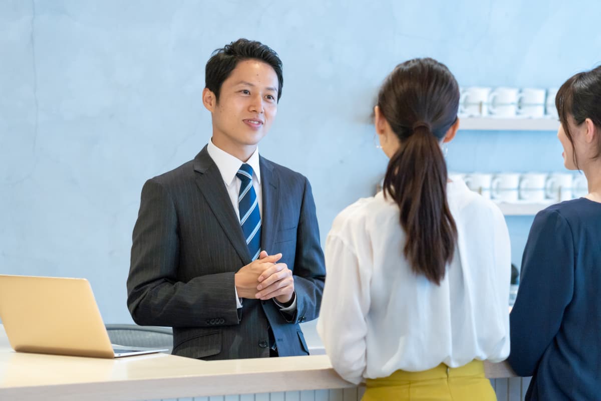 フロントスタッフを話をする宿泊客