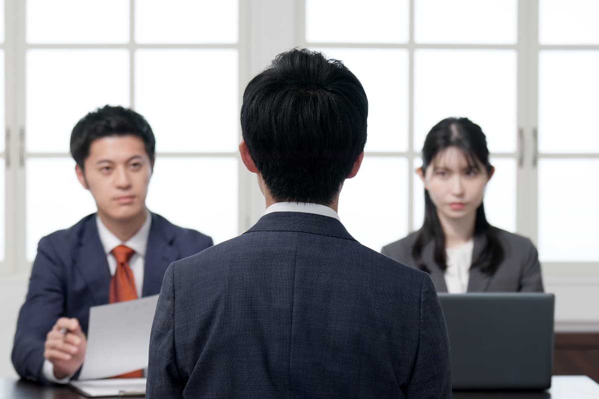 二人の面接官を前に自分の意見を述べる求職者