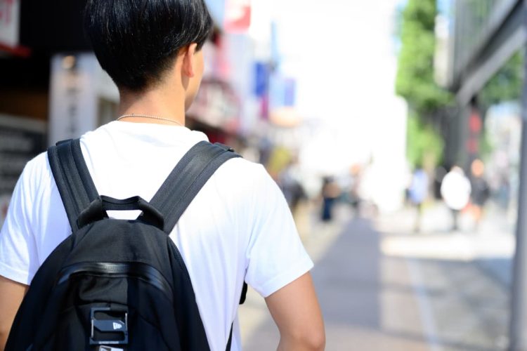 歩道を歩く若い男性