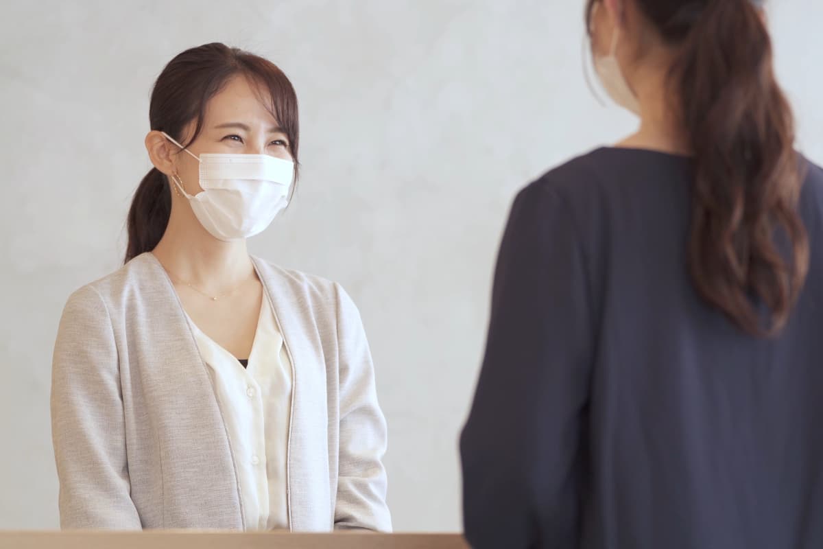 マスクをしながら接客をする女性