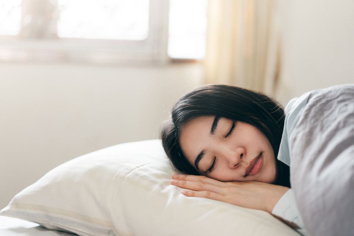 ベッドで眠りにつく女性