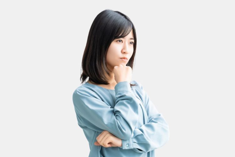 考えごとをしている青い服を着た女性