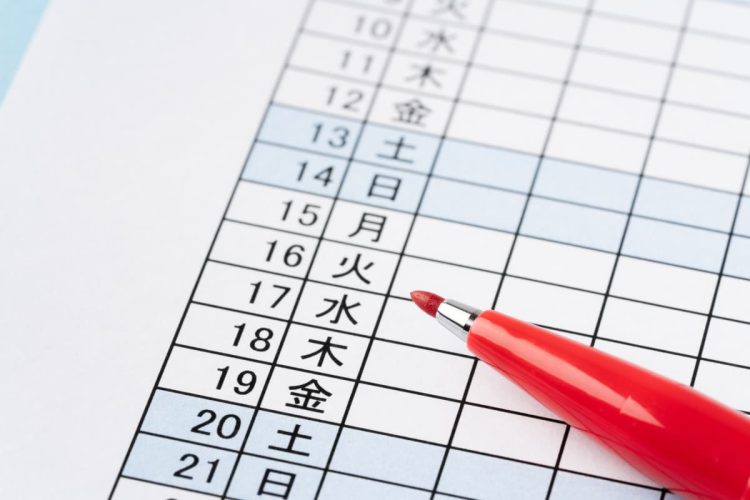 シフト表の上に置かれた赤いペン