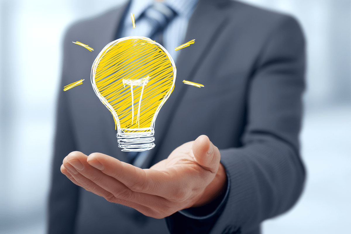 手のひらに浮かぶ電球でひらめきを示すビジネスマンの発想力イメージ