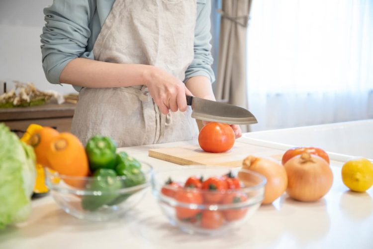 まな板の上で野菜を切る人