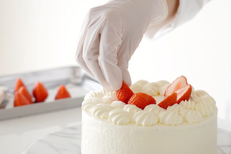 いちごのショートケーキを作るパティシエの手