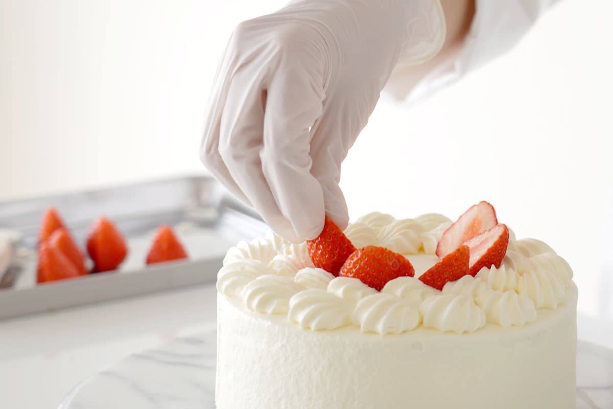 いちごのショートケーキを作るパティシエの手