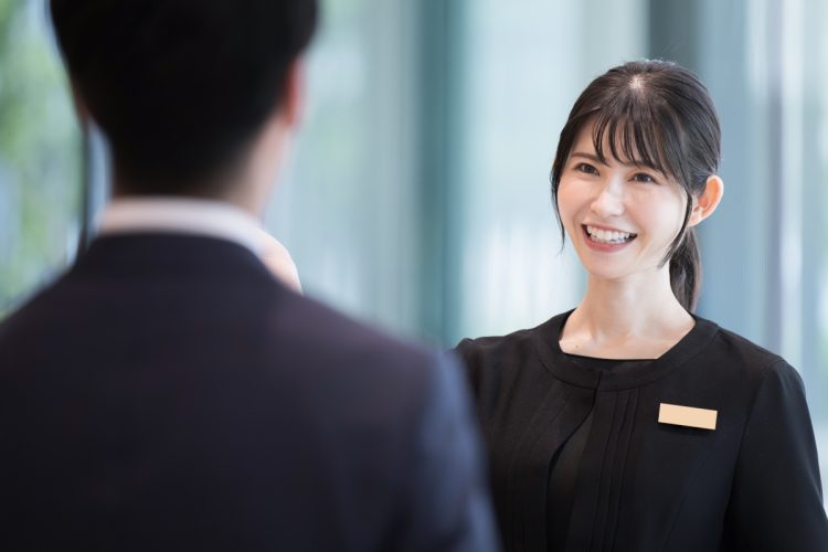 ホテルの受付や案内する接客業の笑顔の日本人女性