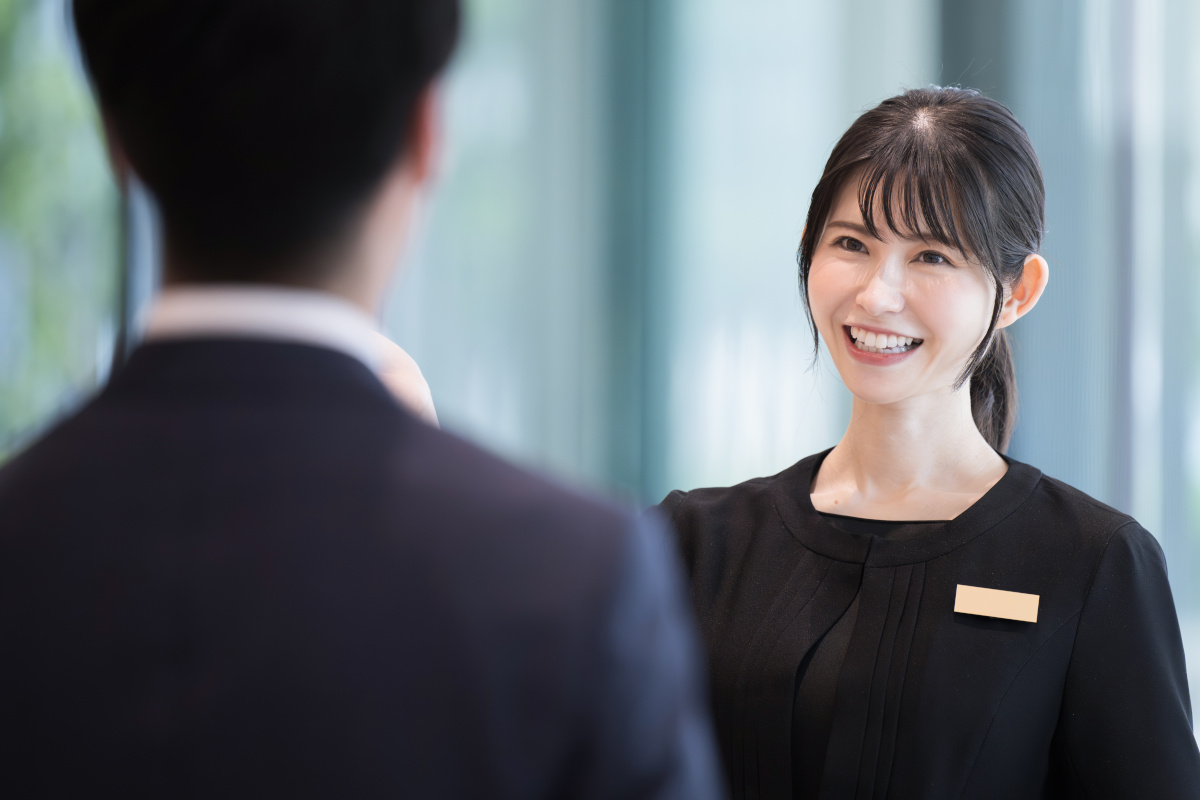 ホテルの受付や案内する接客業の笑顔の日本人女性
