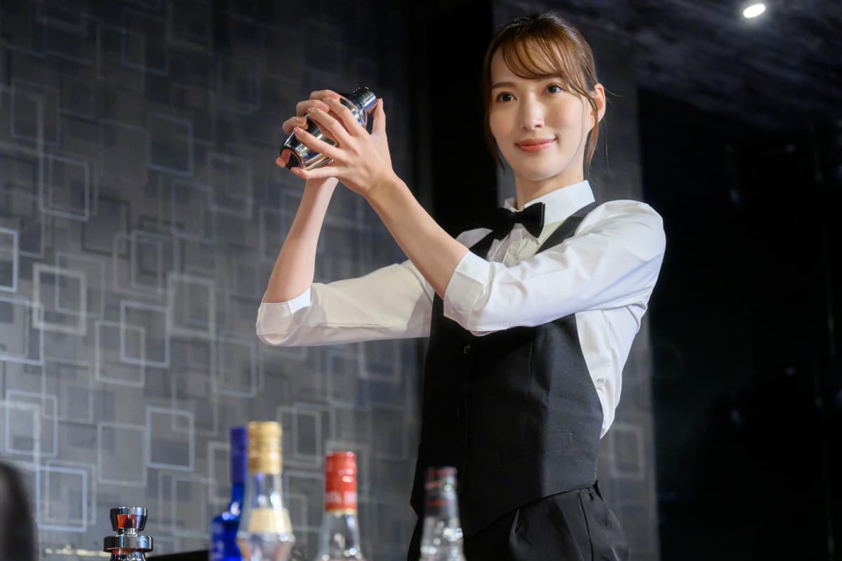カクテルを作る女性のバーテンダー