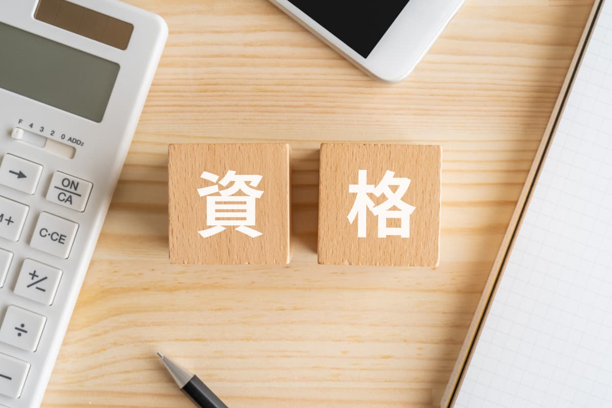 デスクの上に置かれた資格の文字のブロック
