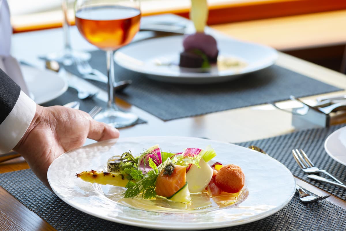 テーブルに料理を置くレストランスタッフ