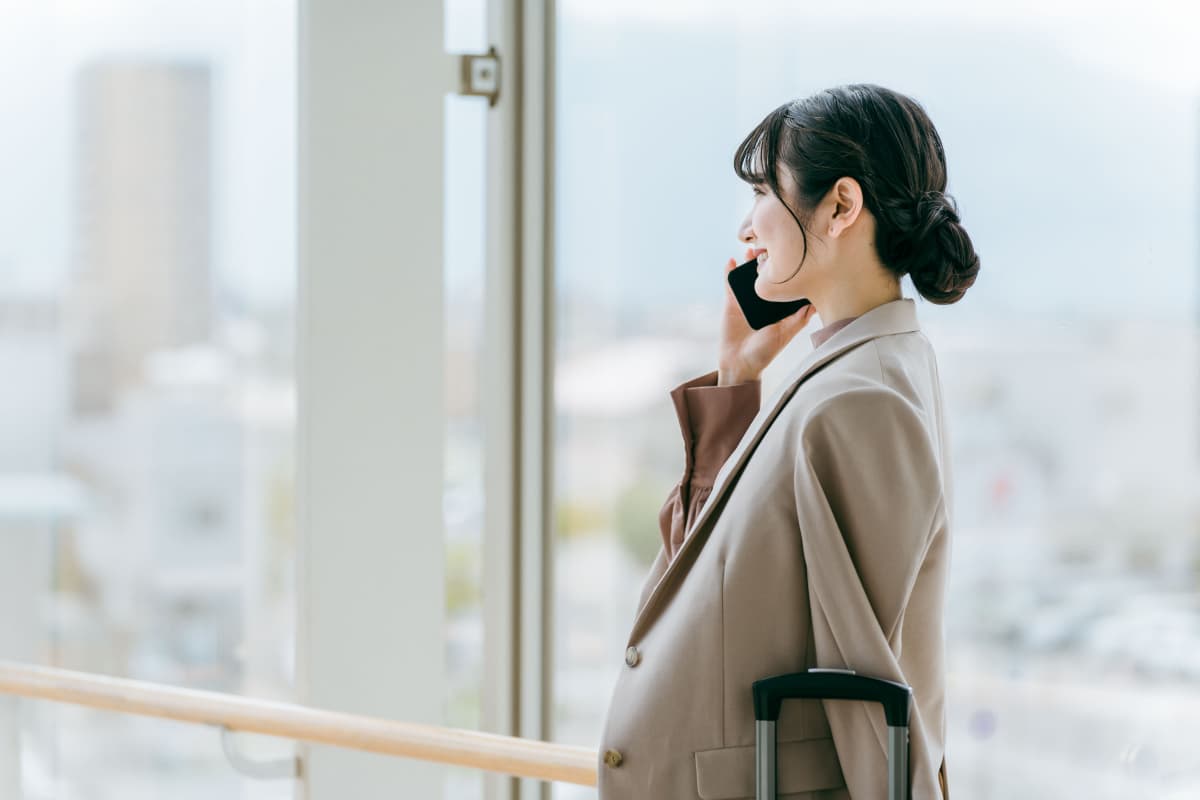 移動中にスマホで電話をするキャリアウーマン